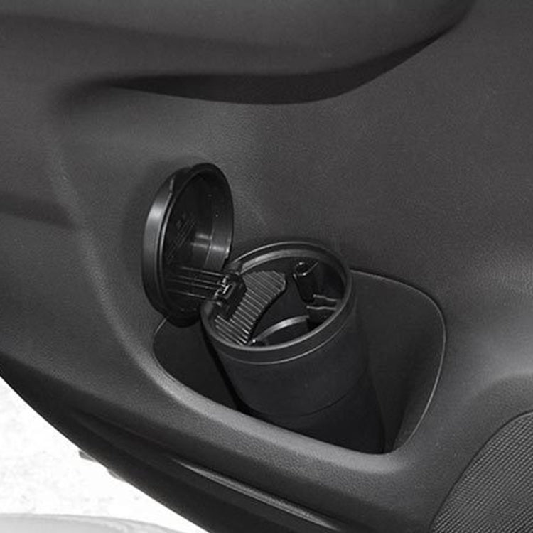 Black car ashtray cup in console opening with lid open and cigarette rest