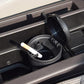 Black car ashtray cup with lid open and cigarette rests inside