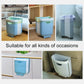 Blue folding trash can in multiple rooms, wall-mounted with top rim opening
