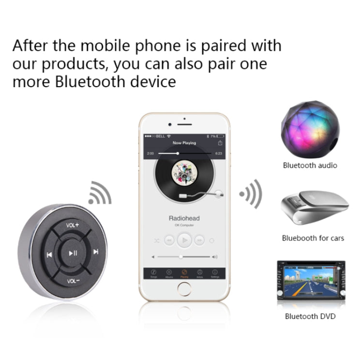 Round Bluetooth car remote controller with play/pause and volume buttons beside phone
