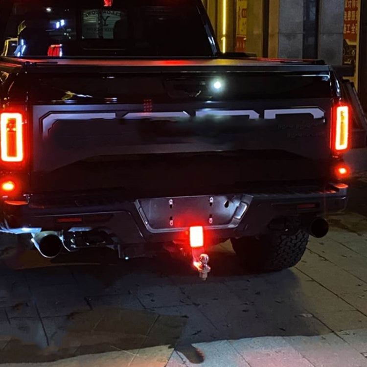 Square LED car light panel lit red on rear vehicle bumper