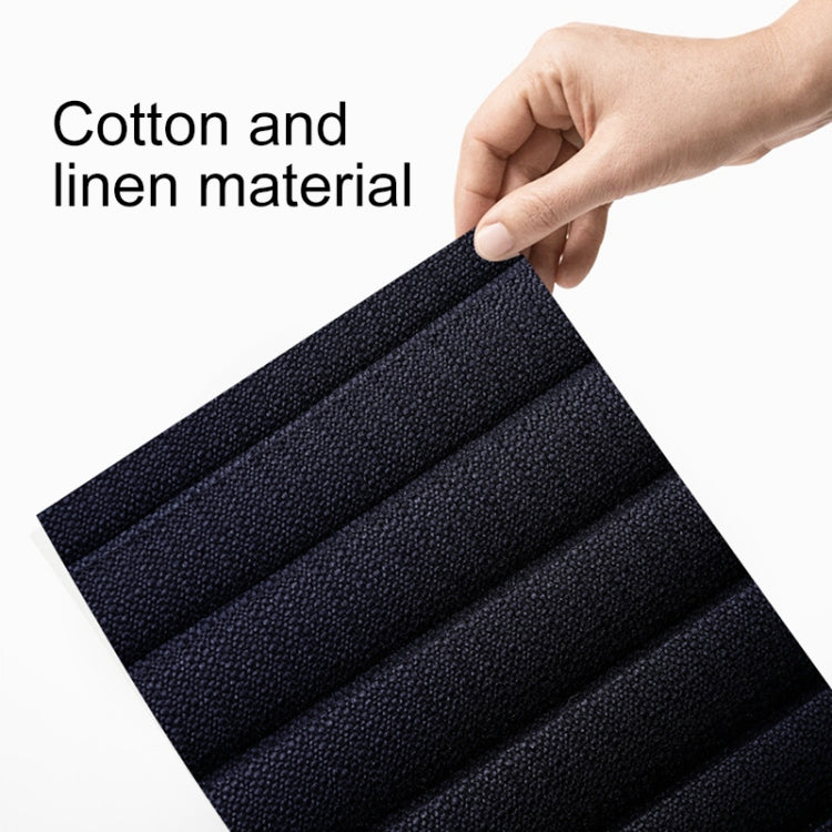 Close-up of dark fabric swatch with textured weave, shown being lifted
