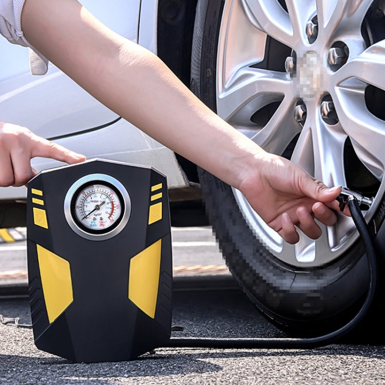 Portable 12V tire inflator pump with gauge, yellow-and-black body, connected to a car tire