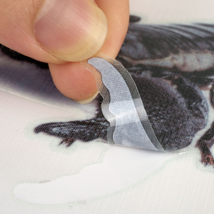 Hand applying scorpion car decal sticker to car panel