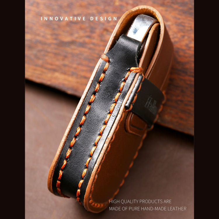 Black leather key cover strap close-up with double stitching, brass loop, and leather edge