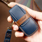 Blue cowhide leather key fob cover held in hand, embossed logo, orange stitching