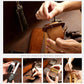 Hands inserting a key fob into a leather protective cover with strap and stitching