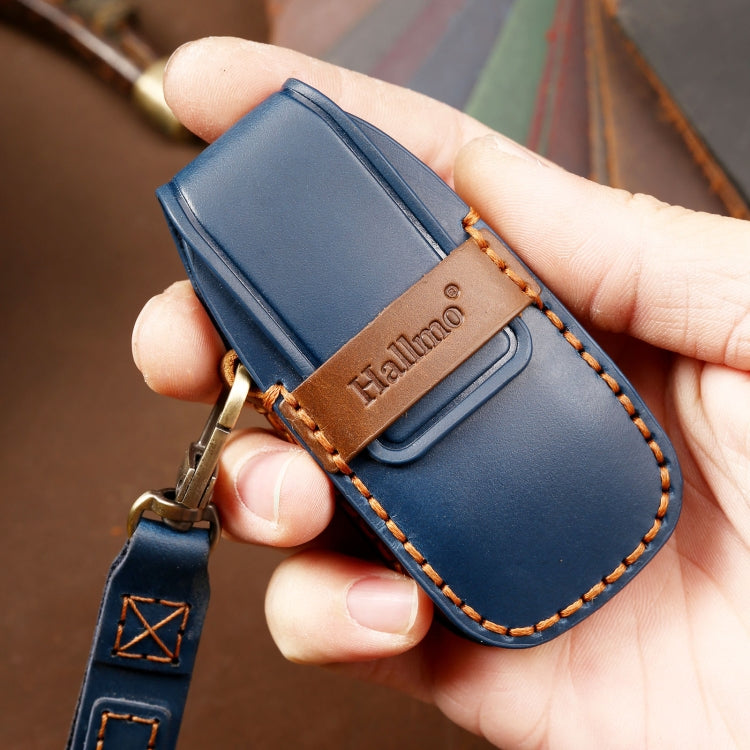 Blue leather key protective cover case held in hand with embossed brand logo
