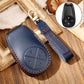 Blue leather key fob cover with circular button design and key strap.