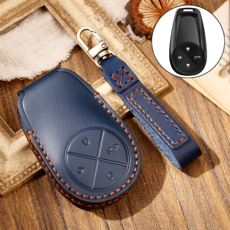 Blue leather key fob cover with circular button design and key strap.