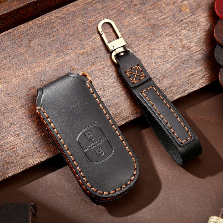 Black leather key case with key ring loop, button cutout, and orange contrast stitching