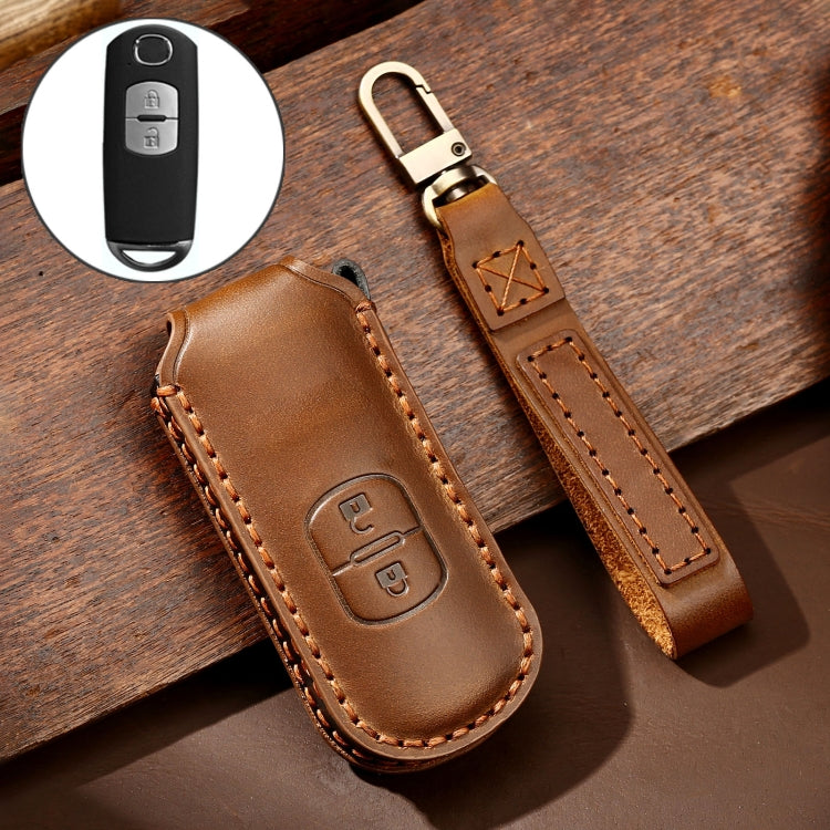 Brown leather key case with button cutout, key ring loop, and tan edge stitching