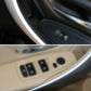Beige inner armrest door handle area with window control switches close-up