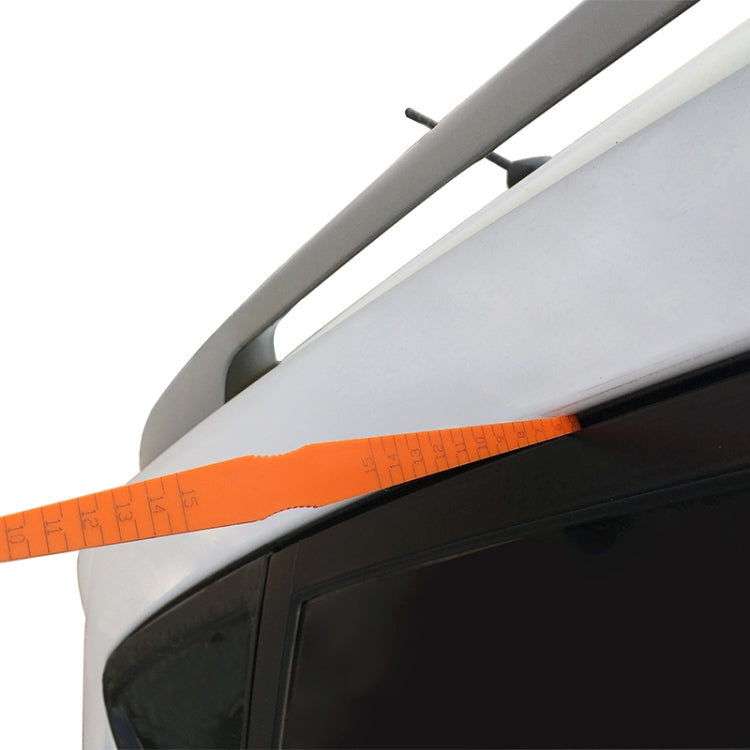 Car hood gap measurement ruler along vehicle edge, orange with printed scale