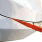 Orange car gap measurement ruler with scale across headlight area seam