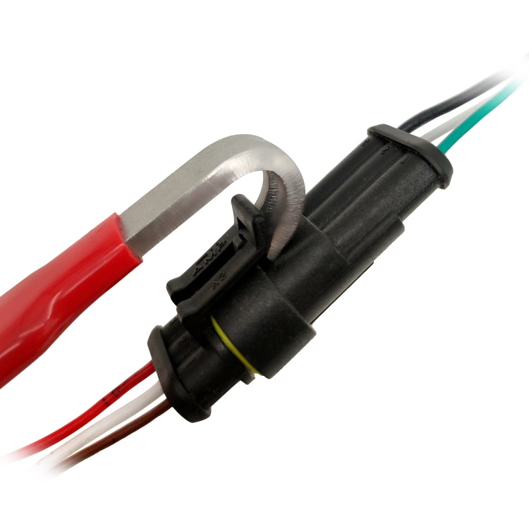 Close-up of red-handled terminal connector separator tool on black connector housing