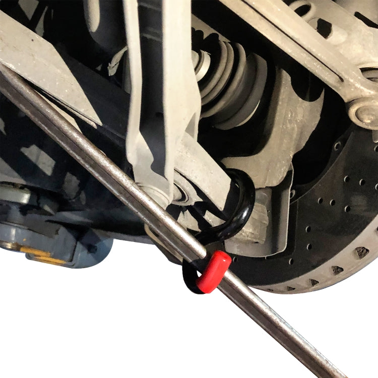 Pry bar tool with red grip separating suspension near perforated brake rotor
