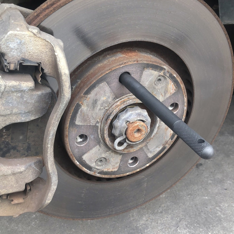 Disc brake wheel alignment tool, black guide pin inserted near hub hardware