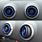 Car dashboard air vents with silver bezels and blue decorative vent rings.