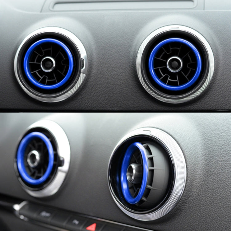 Car dashboard air vents with silver bezels and blue decorative vent rings.