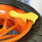 Motorcycle tire changer tool prying a motorcycle tire bead, yellow plastic fork