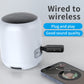Black Bluetooth receiver/transmitter connected to a white wireless speaker