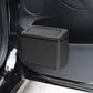 Car interior trash can mounted near door, dark textured plastic bin