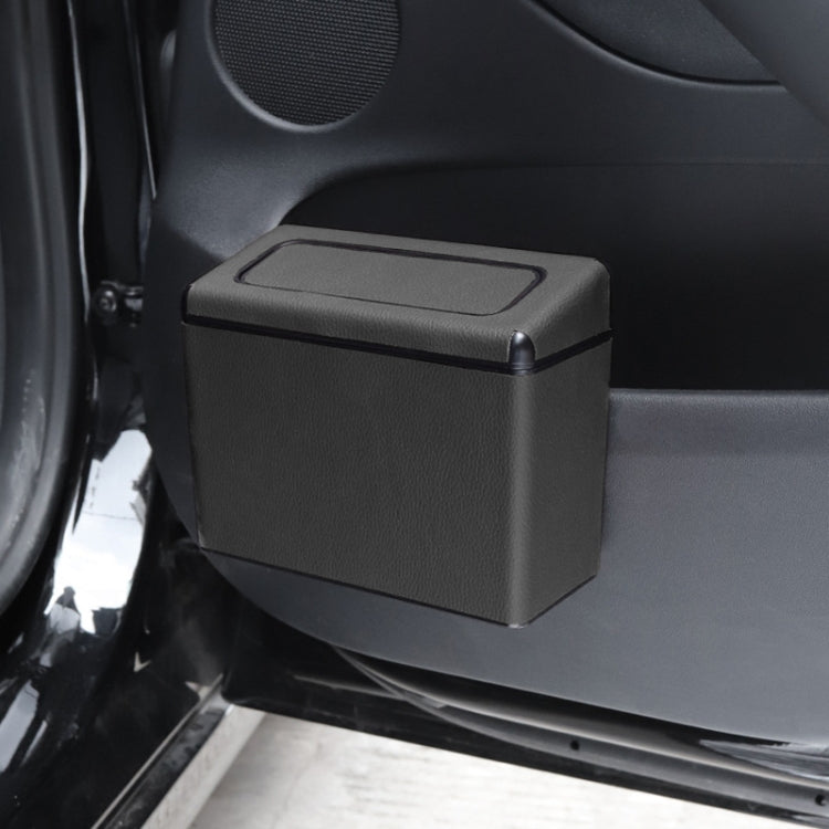 Car interior trash can mounted near door, dark textured plastic bin