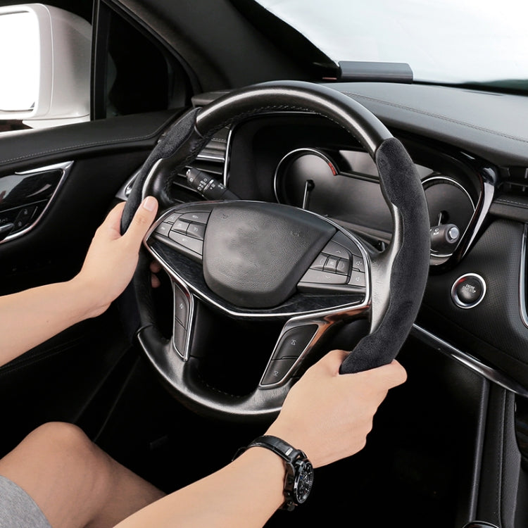 Black suede universal steering wheel cover being placed by hand