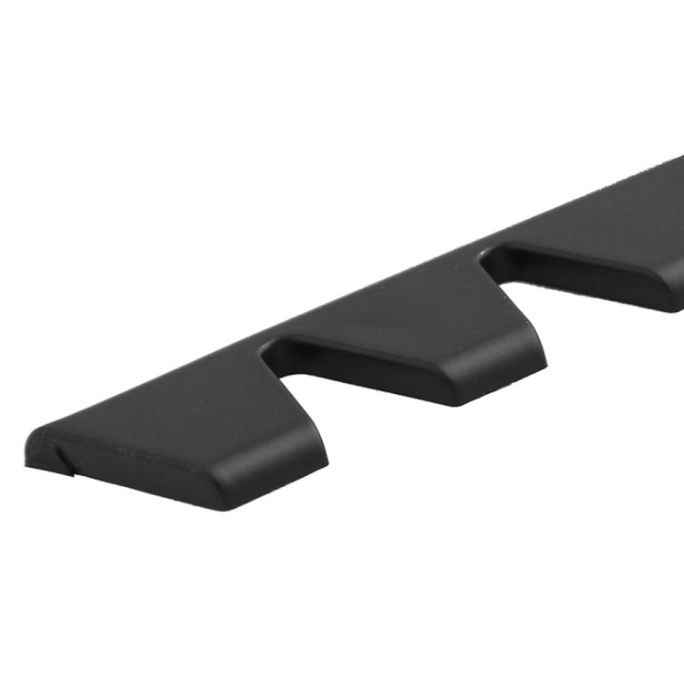 Black bumper guard strip close-up with molded curved tooth-like stops