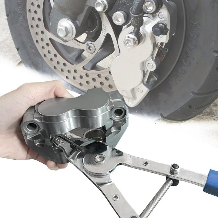 Brake piston removal pliers being used near motorcycle brake caliper and rotor