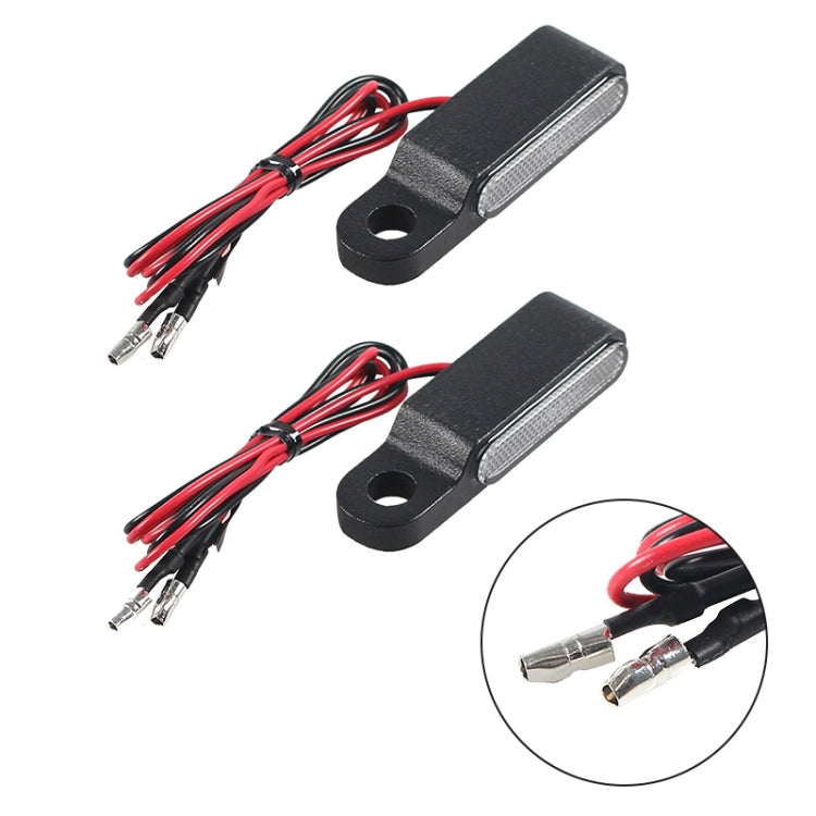 Two black LED turn signal light modules with red and black wiring and metal plugs