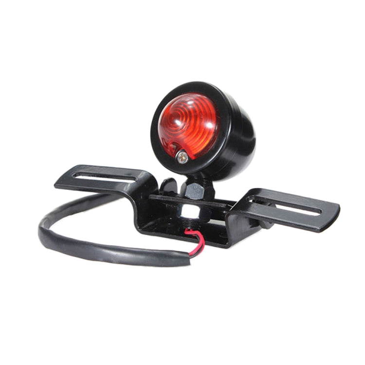 Black mounting bracket with round red rear brake light and connected wiring leads