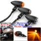 Set of motorcycle retro turn signal lights with black housings and amber plus clear lenses