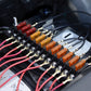 Automotive fuse box installed with colored blade fuses and connected ring terminals on wires