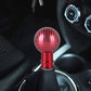 Car gear shift knob with red carbon fiber textured ball top and red metal base