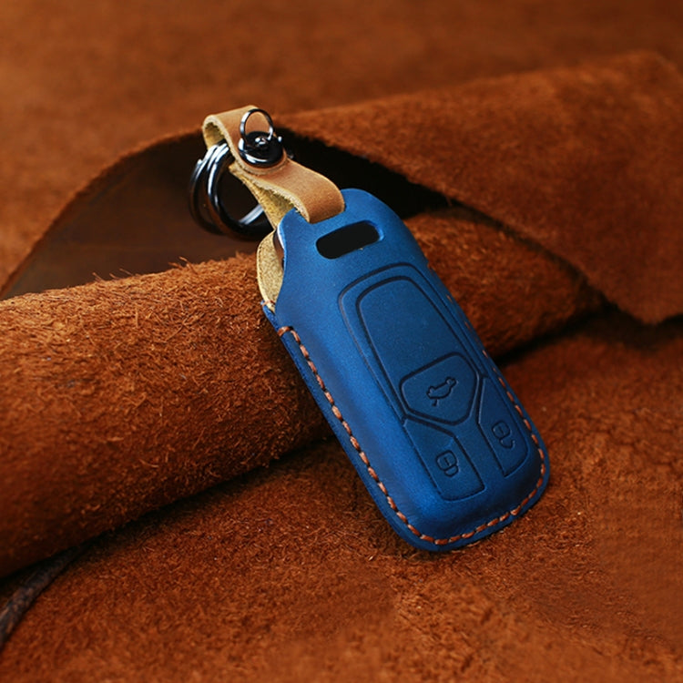Blue leather key fob cover with key ring and embossed buttons, visible stitched trim