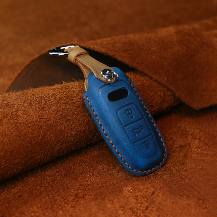 Blue leather key fob cover, stitched seams and embossed button icons with metal ring