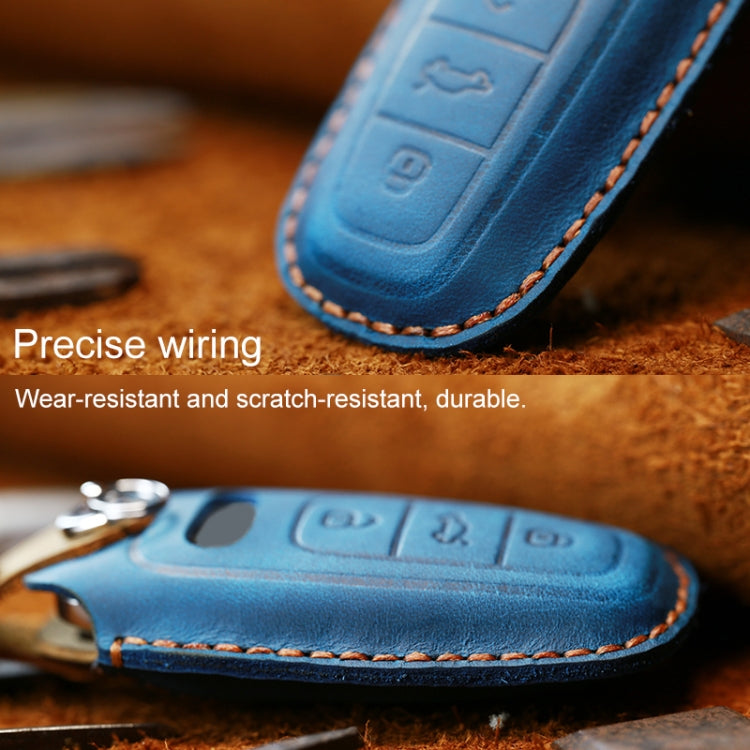 Blue leather key fob cover close-up, stitched edge and embossed button icons