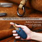 Blue leather key fob cover with metal hook ring, shown in hand