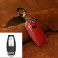 Red leather key fob cover with metal ring, stitched edge and button icon embossing
