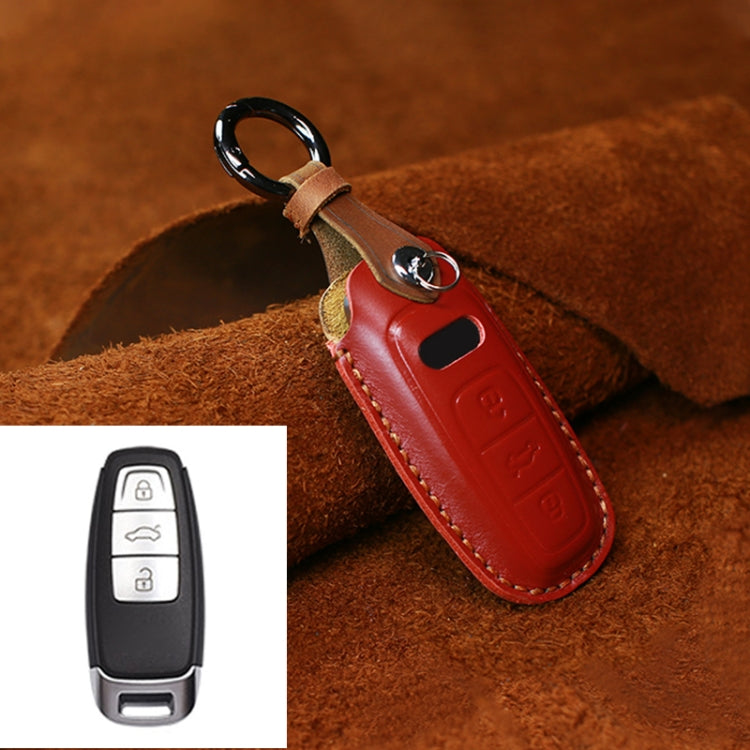 Red leather key fob cover with metal ring, stitched edge and button icon embossing