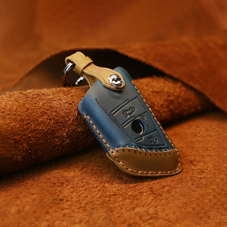 Blue leather key protective cover case with metal keyring, stitched edges, and key button cutout