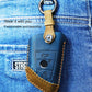 Blue leather key cover with metal keyring attached to denim loop