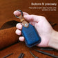 Blue leather key fob cover held in hand with key ring loop and embossed button controls.