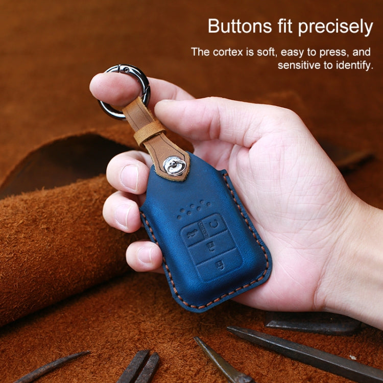 Blue leather key fob cover held in hand with key ring loop and embossed button controls.