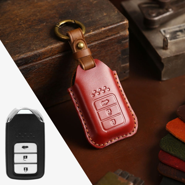 Red leather key fob cover with key ring loop and embossed control buttons with tan stitching.