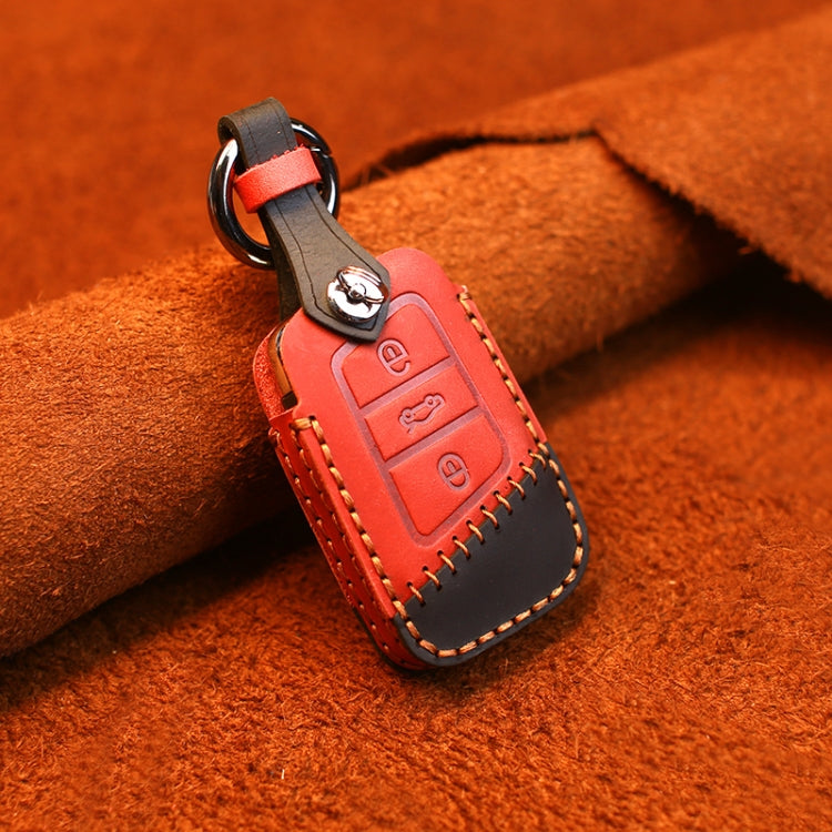 Red leather key cover with dark trim, metal ring, and stitched edges over button panel