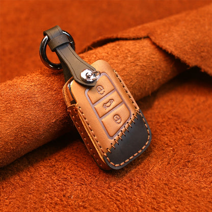 Brown leather key cover case with metal ring, stitched edges, and button key cutout