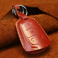 Red leather key fob cover with embossed buttons, red-stitched edge and key ring